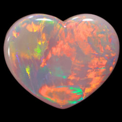 Heart shaped white opal on white background showing neon fire